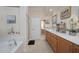 Bright bathroom with double sinks, a soaking tub, glass shower, and neutral tiling at 1030 Thoughtful Spot Ln, Durham, NC 27703