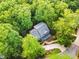 Aerial view features a green home nestled among dense trees, complemented by a winding driveway at 104 Windorah Place Pl, Chapel Hill, NC 27517