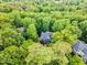 Aerial view showing a green home surrounded by lush trees, offering privacy and curb appeal at 104 Windorah Place Pl, Chapel Hill, NC 27517