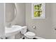 Clean half bathroom with hardwood floors, modern sink, toilet, and window at 104 Windorah Place Pl, Chapel Hill, NC 27517
