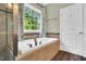Bathroom featuring a soaking tub underneath a large window with beautiful wooded views at 104 Windorah Place Pl, Chapel Hill, NC 27517