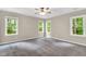 Sunlit bedroom with neutral walls, carpet flooring, and many windows with wooded views at 104 Windorah Place Pl, Chapel Hill, NC 27517