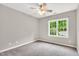 Cozy carpeted bedroom featuring a ceiling fan and a window with natural light at 104 Windorah Place Pl, Chapel Hill, NC 27517