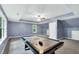 Well-lit bonus room featuring a ceiling fan, air hockey table, and two windows at 104 Windorah Place Pl, Chapel Hill, NC 27517