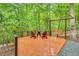 Outdoor deck featuring chairs, a swing, and a fire pit with a wooded background at 104 Windorah Place Pl, Chapel Hill, NC 27517