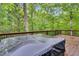 Back deck with a covered hot tub, wood decking, and scenic wooded views at 104 Windorah Place Pl, Chapel Hill, NC 27517