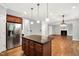 Eat-in kitchen and living space with hardwood floors, center island, and fireplace at 104 Windorah Place Pl, Chapel Hill, NC 27517