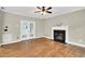 Bright living room featuring a fireplace, hardwood flooring, and double doors to another room at 104 Windorah Place Pl, Chapel Hill, NC 27517