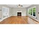 Well-lit living room with hardwood floors, fireplace, and large windows, offering ample natural light at 104 Windorah Place Pl, Chapel Hill, NC 27517