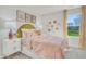 Charming bedroom with large windows, yellow headboard, neutral colors, and decorative accents at 1043 Winding Spring Dr, Mebane, NC 27302