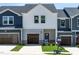 New construction townhome with a garage, modern design, and a well-manicured lawn at 1043 Winding Spring Dr, Mebane, NC 27302
