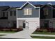 Rendering of townhome featuring blue siding, white trim, a garage, and landscaped front yard at 1043 Winding Spring Dr, Mebane, NC 27302