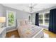 Bright bedroom with hardwood floors, multiple windows, ceiling fan, and a pink quilt at 106 Bluefield Rd, Chapel Hill, NC 27517