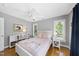Bright bedroom with hardwood floors, multiple windows, ceiling fan, and a pink quilt at 106 Bluefield Rd, Chapel Hill, NC 27517