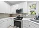 Modern kitchen featuring stainless steel appliances, white cabinetry and geometric tile backsplash at 106 Bluefield Rd, Chapel Hill, NC 27517