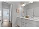 Well-lit bathroom featuring a double vanity with white cabinetry and views into the laundry room at 108 Valley View Dr, Chapel Hill, NC 27516