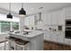 Bright kitchen showcasing white cabinetry, a subway tile backsplash, and an island with barstool seating at 108 Valley View Dr, Chapel Hill, NC 27516