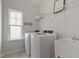 Practical laundry room featuring modern, front-loading machines and ample storage space at 108 Valley View Dr, Chapel Hill, NC 27516