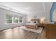 Sun-filled main bedroom with a king-size bed, wood flooring, white and blue color scheme, and lots of natural light at 108 Valley View Dr, Chapel Hill, NC 27516