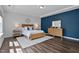 Modern main bedroom with a king-size bed, wood flooring, white and blue color scheme, and lots of natural light at 108 Valley View Dr, Chapel Hill, NC 27516