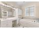 Bright bathroom featuring a soaking tub, double sink vanity, and elegant white cabinetry at 1093 N Lakeside Dr, Smithfield, NC 27577