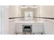 A bathroom vanity features a black chair and large mirror reflecting the bright, tiled space at 1093 N Lakeside Dr, Smithfield, NC 27577