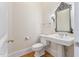 Elegant powder room with a pedestal sink, detailed mirror, and wood flooring at 1093 N Lakeside Dr, Smithfield, NC 27577