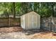 Backyard features a storage shed with double doors, surrounded by lush landscaping and a wooden fence at 1148 Dexter Ridge Dr, Holly Springs, NC 27540