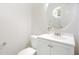 Cozy half bathroom featuring white walls, a decorative mirror, and a white vanity with storage at 1148 Dexter Ridge Dr, Holly Springs, NC 27540