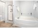 Bright bathroom features a soaking tub and separate glass enclosed shower at 1148 Dexter Ridge Dr, Holly Springs, NC 27540