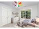 Cozy bedroom featuring a colorful fan, natural light, and neutral decor at 1148 Dexter Ridge Dr, Holly Springs, NC 27540