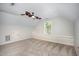 Spacious bonus room with neutral carpet, large window, and ceiling fan at 1148 Dexter Ridge Dr, Holly Springs, NC 27540