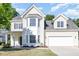 Inviting two-story home with a two-car garage, bay window and manicured lawn and yellow siding at 1148 Dexter Ridge Dr, Holly Springs, NC 27540
