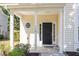 Charming front porch featuring classic columns and a black front door with sidelights at 1148 Dexter Ridge Dr, Holly Springs, NC 27540