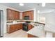 Open kitchen with granite countertops, stainless steel sink, wood cabinets, and black appliances at 1148 Dexter Ridge Dr, Holly Springs, NC 27540
