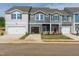 New construction townhomes with single car garages and colorful front doors on a sunny day at 1167 Abbott St, Mebane, NC 27302