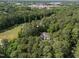 Aerial view of a home nestled amongst lush, mature trees in a serene setting at 120 Harmony Hill Ln, Cary, NC 27513