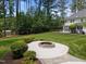 Spacious backyard with fire pit, manicured lawn, and wooded backdrop at 120 Harmony Hill Ln, Cary, NC 27513