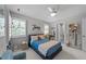 Well-lit bedroom with blue accents, fan, shelves, and nearby bathroom at 120 Harmony Hill Ln, Cary, NC 27513