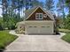 Exterior of home featuring a three-car garage, and lush landscaping at 120 Harmony Hill Ln, Cary, NC 27513