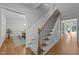 An open foyer showcases hardwood floors and a staircase with iron spindles and a view of the dining room at 120 Harmony Hill Ln, Cary, NC 27513