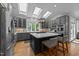 Bright kitchen featuring stainless steel appliances, a kitchen island with seating and gray cabinets and countertops at 120 Harmony Hill Ln, Cary, NC 27513