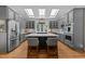 Spacious kitchen featuring a large island with seating, stainless steel appliances, and abundant natural light from skylights at 120 Harmony Hill Ln, Cary, NC 27513