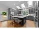 Large kitchen island with seating, stainless steel refrigerator, skylights, and gray cabinetry create a chef's dream at 120 Harmony Hill Ln, Cary, NC 27513