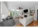 Bright living room with large windows, a fireplace, built-in shelves, and hardwood floors at 120 Harmony Hill Ln, Cary, NC 27513