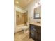 Well-lit bathroom with tiled floors, a shower-tub combo, and a dark vanity at 12317 Richmond Run Dr, Raleigh, NC 27614