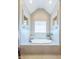 Bathroom with a soaking tub, tiled walls, a window, and an indoor plant to add beauty at 12317 Richmond Run Dr, Raleigh, NC 27614