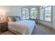 Bedroom with large arched windows, a comfortable bed, and a cozy window-side desk at 12317 Richmond Run Dr, Raleigh, NC 27614