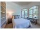 Bedroom with large arched windows, a comfortable bed, a nightstand, and a cozy window-side desk at 12317 Richmond Run Dr, Raleigh, NC 27614