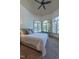 Bedroom with large arched windows, a comfortable bed, and a cozy window-side desk at 12317 Richmond Run Dr, Raleigh, NC 27614